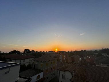 Nefes kesici bir günbatımı güzel renklerini ön planda belirgin şekilde duran sayısız yüksek binalarla dolu bir şehir manzarasına yansıtıyor.