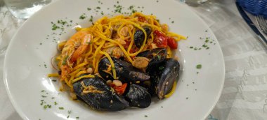 İstiridye, midye ve vişneli domatesli bir tabak spagetti. Yüksek kalite fotoğraf