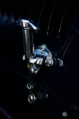 Bu parlak metal bir nesnenin yakın plan görüntüsüdür. Bu nesnenin özgün özelliklerini ve detaylarını vurgulayan koyu siyah bir arkaplan üzerine kuruludur.