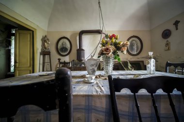 Güzel bir masa ve zarif sandalyelerin olduğu büyüleyici bir yemek odası. Karakterle dolu, eski, antika bir evde.