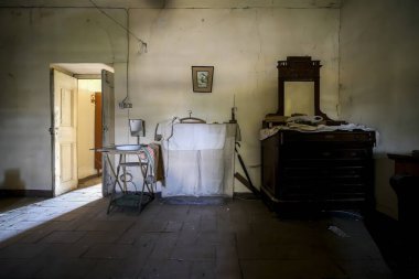 Odanın ortasında bir dikiş makinesi var. Dikkatimizi onun varlığına ve işlevselliğine çekiyor.