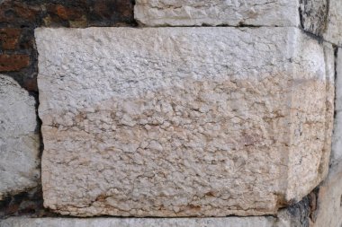 Bu, belirgin ve dayanıklı bir dokuyu barındıran taş bir duvarı gösteren detaylı bir yakın çekim görüntüsü. Gerçekten büyüleyici.