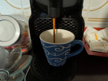 Tadını çıkarmaya hazır bir kahve makinesine buharlı, aromatik bir fincan dolduruluyor.