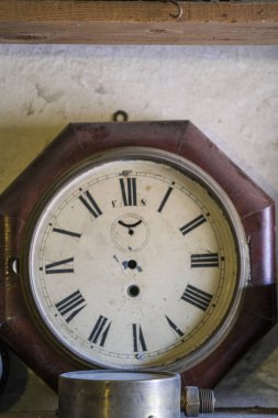 Zarif Roma rakamlarına sahip güzel bir saat zarif bir şekilde ahşap bir masaya yerleştirilir ve çevrenin estetiğine eklenir.