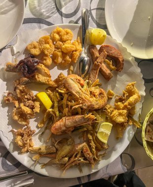 Masada lezzetli karideslerle dolu lezzetli bir tabak var. Yanında da çıtır çıtır patates kızartması var.