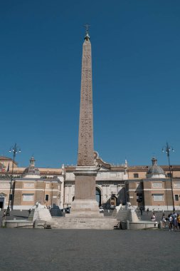 The Flaminio Obelisk stands tall in Piazza del Popolo, Rome. This ancient Egyptian obelisk is a prominent landmark in the historic square. Ideal for travel, history, and Rome themes. clipart