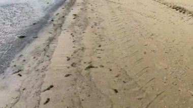 Adriyatik kıyıları, Rimini, İtalya 'da popüler bir yer olan Cesenatico plajındaki ıslak kumu ayak izleri gösteriyor..