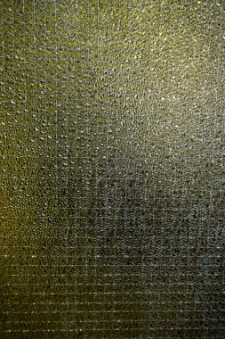 Özyinelenen soyut desenli yeşil camların yakın çekimi ışık ve gölgelerle benzersiz bir görsel etki yaratıyor. Yüksek kalite fotoğraf