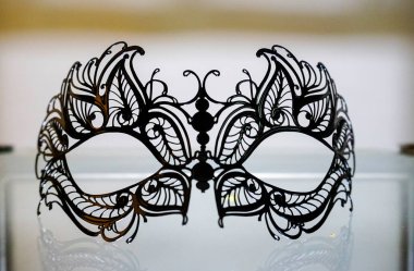 Venedik maskesinin yakın plan bir resmi. Karmaşık siyah dantel tasarımı ve dekoratif özellikleri vurgulanıyor. Yüksek kalite fotoğraf