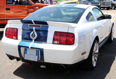 Carpi Modena, İtalya: 2009 07 06 Serbest Sürüş Yarışı Açık havada belirgin mavi yarış çizgileri olan beyaz Shelby Mustang klasik Amerikan kaslı araba tasarımı ve çekiciliğini yakaladı. Yüksek kalite fotoğraf