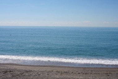 Amalfi Sahili 'nden sakin bir okyanus manzarası, sakin mavi suları, uzak kuşları ve soluk dağları, huzurlu kıyı manzarasını yakalıyor. Yüksek kalite fotoğraf