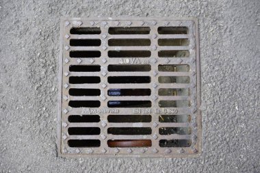 Şehir altyapısının tasarımı ve işlevselliğini vurgulayan beton kanalizasyon ızgarasının ayrıntılı bir görüntüsü. Yüksek kalite fotoğraf