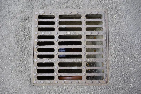 Şehir altyapısının tasarımı ve işlevselliğini vurgulayan beton kanalizasyon ızgarasının ayrıntılı bir görüntüsü. Yüksek kalite fotoğraf