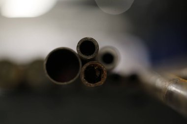 Çeşitli metal boruların yakın plan görüntüsü. Uçları ve iç kısımları bulanık bir arka plan ile gösteriliyor. Yüksek kalite fotoğraf