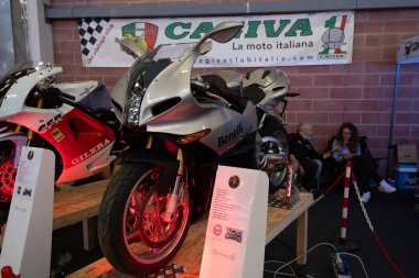 Modea, İtalya: 2025 03 Motor Festivali Fuarı Motosikleti A Silver Benelli Tornado motosikleti kapalı bir otomotiv etkinliğinde diğer İtalyan motosiklet markalarıyla birlikte sergilenmektedir. Yüksek kalite fotoğraf