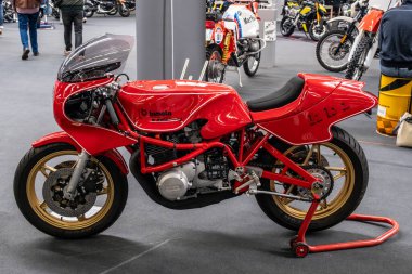 Modea, İtalya: 2025 03 03 30 Motor Festivali Fuarı Motosikleti altın tekerlekli canlı kırmızı Bimota KB1 motosikleti İtalya 'da düzenlenen klasik bir motosiklet etkinliğinde kapalı mekanda sergilenmektedir. Yüksek kalite fotoğraf