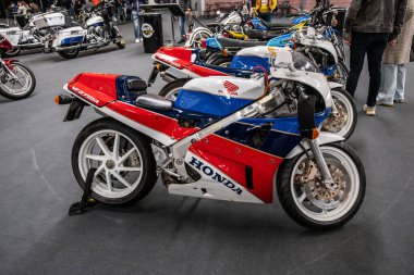 Modea, İtalya: 2025 03 03 Motor Festivali Fuarı Motorsiklet A klasik Honda VFR750R RC30 motosiklet, İtalya 'da düzenlenen bir motosiklet etkinliğinde kendine özgü kırmızı, beyaz ve mavi üniformasıyla sunulmaktadır. Yüksek kalite fotoğraf