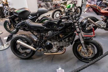 Modea, İtalya: 2025 03 Motor Festivali Fuarı Motosikleti. Modern İtalyan tasarımını ön plana çıkaran siyah Ducati Monster motosikleti kapalı alanda sergilenmektedir. Yüksek kalite fotoğraf