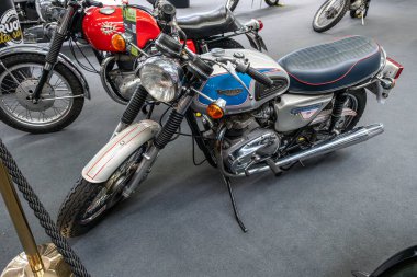 Modena, İtalya: 2025 03 30 Motor Festivali Fuarı Motorsiklet A gümüş ve mavi 1977 Triumph Bonneville T140J motosiklet sergilenmektedir. Yüksek kalite fotoğraf