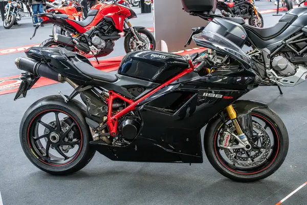Modena, İtalya: 2025 03 Motor Festivali Fuarı Motosiklet A siyah Ducati 1198 SP spor motosiklet kırmızı aksanlı gri zeminde bir motosiklet sergisinde sergilenmektedir. Yüksek kalite fotoğraf