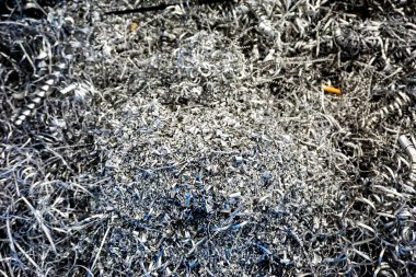 Yakından bakınca, parlak, kıvrımlı metal parçacıkları ve keskin talaşlar, makine veya imalat sürecinden arta kalanlar görülüyor. Yüksek kalite fotoğraf
