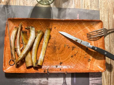 Yemekten sonra, çatal ve bıçakla servis tabağında kalan kaburga kemiklerinin yakın çekimi. Yüksek kalite fotoğraf