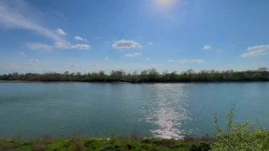  İtalya 'nın Cremona yakınlarındaki Po Nehri' nin geniş, sakin manzarası yemyeşil bankalar, uzak ağaçlar ve seyrek bulutlu açık mavi bir gökyüzü..