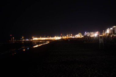 Geceleri Cesenatico plajı, kıyı şeridi otellerin ve işletmelerin uzak ışıklarını yansıtarak parlayan bir deniz manzarası yaratıyor. Yüksek kalite fotoğraf