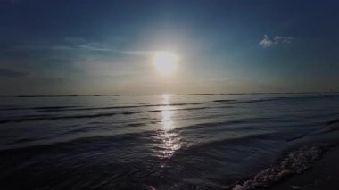 Güneş Adriyatik Denizi 'nin üzerinde şafak vakti Rimini' de yükselir, suya altın bir yansıma yapar ve sakin bir sahil manzarası yaratır. Yüksek kalite 4k görüntü