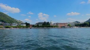 Como, İtalya 'nın manzaralı panoramik manzarası, Como Gölü' nün suyundan görüldüğü gibi, renkli binalar ve yemyeşil tepeler var..