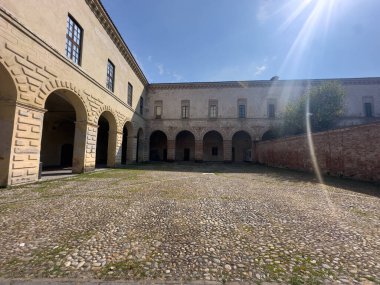 Melegnano 'nun büyük tarihi Visconti Kalesi güneşli bir günde yemyeşil bir parkın arkasında görkemli bir şekilde duruyor. Yüksek kalite fotoğraf