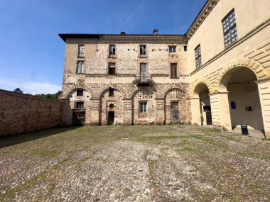Melegnano 'nun büyük tarihi Visconti Kalesi güneşli bir günde yemyeşil bir parkın arkasında görkemli bir şekilde duruyor. Yüksek kalite fotoğraf