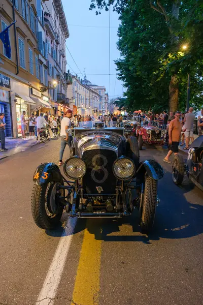 Parma, İtalya: 2025 06 20 Mille Miglia klasik rali klasik araba yarışı, klasik siyah yarış arabası, numara 8, Mille Miglia etkinliği sırasında gece bir şehir sokağında sürüyor. Yüksek kalite fotoğraf