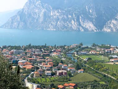 Garda Gölü kıyısındaki Torbole 'un güzel panoramik manzarası ve etrafındaki dağlar berrak bir gökyüzünün altında. Yüksek kalite fotoğraf