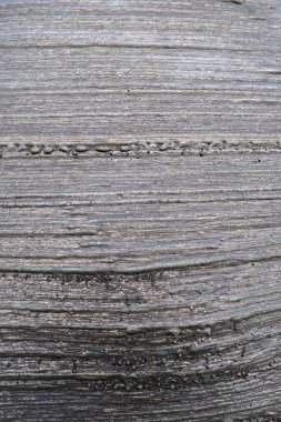 Paralel, yatay çizgiler ve kaba, granüler bir kaplama ile koyu, desenli metal bir yüzeyin yakın çekimi endüstriyel bir zemin oluşturur. Yüksek kalite fotoğraf