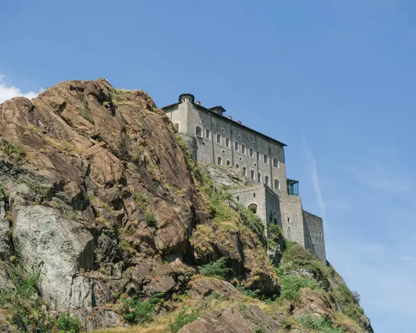 Ozan 'ın görkemli kalesi, muazzam bir askeri yapı, İtalya' nın Aosta Vadisi 'ndeki berrak mavi gökyüzünün altında kayalık bir uçurumun kenarında duruyor. Yüksek kalite fotoğraf