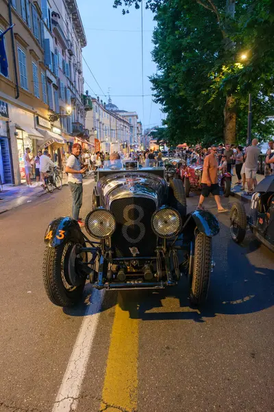 Parma, İtalya: 2025 06 20 Mille Miglia klasik rali klasik araba yarışı, klasik bir Bentley yarış arabası tarihi bir İtalyan kasabasında seyircilerin arasından geçiyor. Yüksek kalite fotoğraf