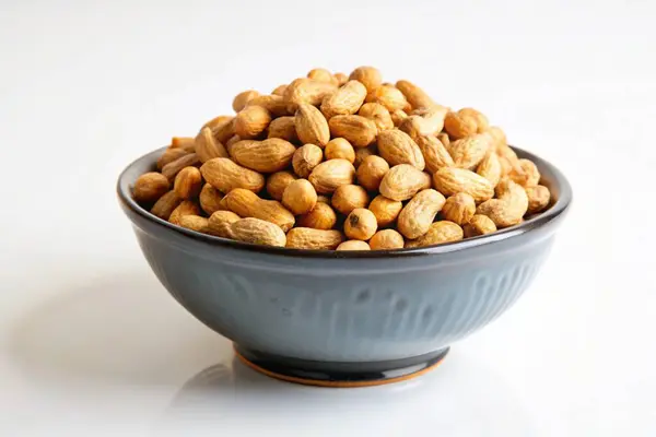 stock image Roasted peanuts in a bowl isolated on white background