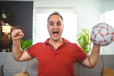 Evde maç izleyen heyecanlı orta yaşlı adam..