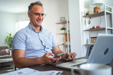 Orta yaşlı beyaz adam internetten alışveriş yapıyor..