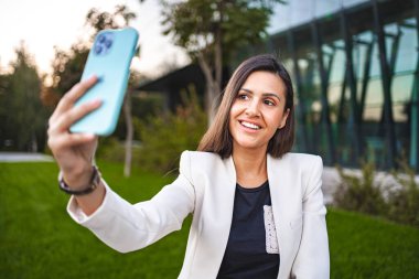 İş kadını işten sonra telefonda selfie çekiyor..