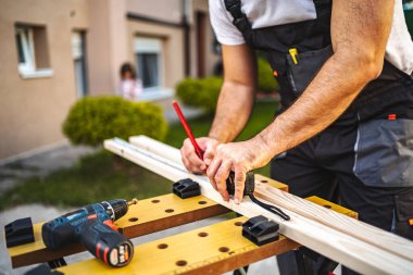 Tanımlanamayan adamlar dışarıda tahta ölçüyorlar..