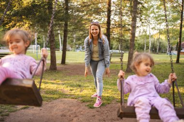 Annem parkta salıncakta ikiz kızlarını sallıyor..
