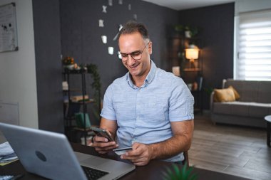 Orta yaşlı beyaz adam internetten alışveriş yapıyor..