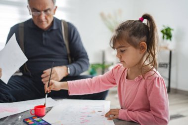 Bir kızın büyükbabasıyla resim yaptığı hoş bir yaratıcılık anı..