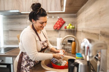 Kadın mutfakta bulaşık yıkıyor..