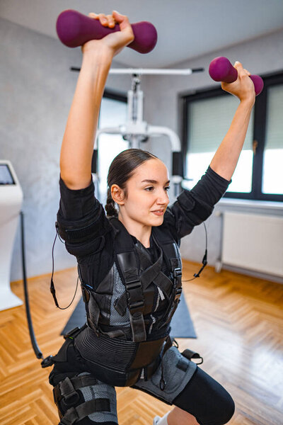 A focused individual engages in strength training using weights in a gym.