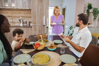 Arkadaşlar ve aile, güzel yemekler ve kahkahalarla keyifli bir akşam yemeği yer..