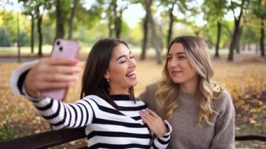 Arkadaşlar güz yaprakları arasında selfie çekerken gülüşlerini paylaşırlar..