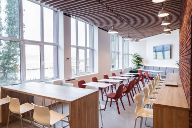 Bu odada çok sayıda sandalyeyle çevrili uzun bir masa var. Sandalyeler düzenli bir şekilde kurulmuş, toplantı veya etkinlik için hazırlar. Oda aydınlık ve ferah, profesyonel ve...